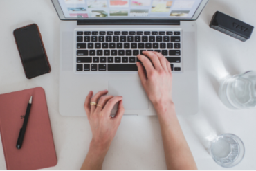 Homem sorrindo cria um curso online em seu computador, fundo digital desfocado.