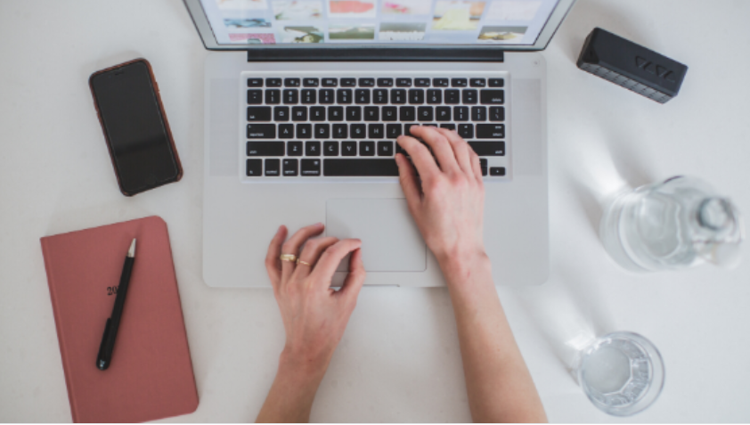 Homem sorrindo cria um curso online em seu computador, fundo digital desfocado.