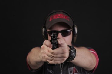 Atirador demonstrando técnica de tiro dinâmico em competição