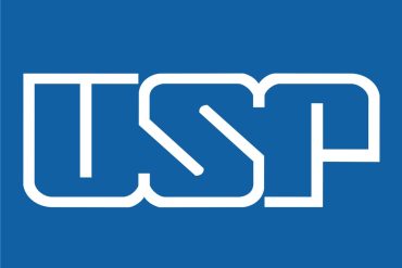 Estudante de medicina focado em laptop com gráficos de monitor cardíaco na tela, símbolo de terapia intensiva