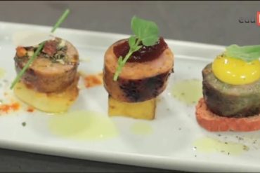 Estante cheia de linguiças artesanais e embutidos variados em um ambiente de charcutaria profissional.